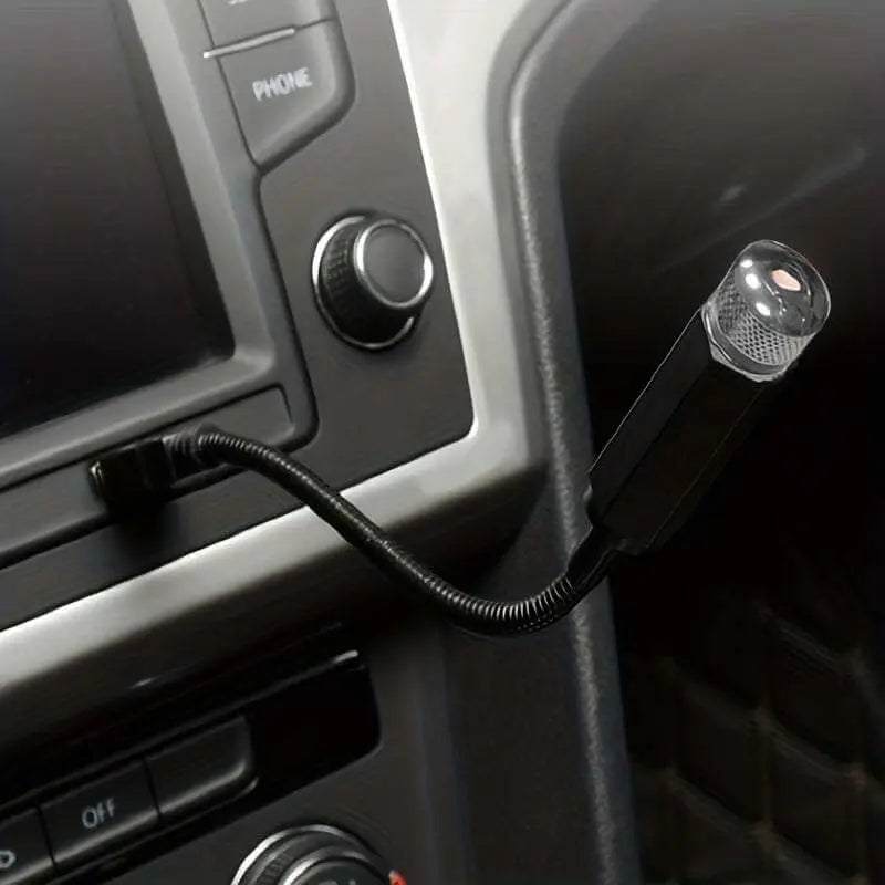 USB Star Projector Night Light in a car's USB port, projecting starry patterns onto the interior ceiling, creating a romantic atmosphere.