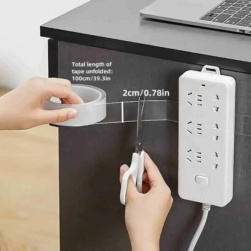 Person cutting Nano Double-Sided Tape to mount power strip on desk.