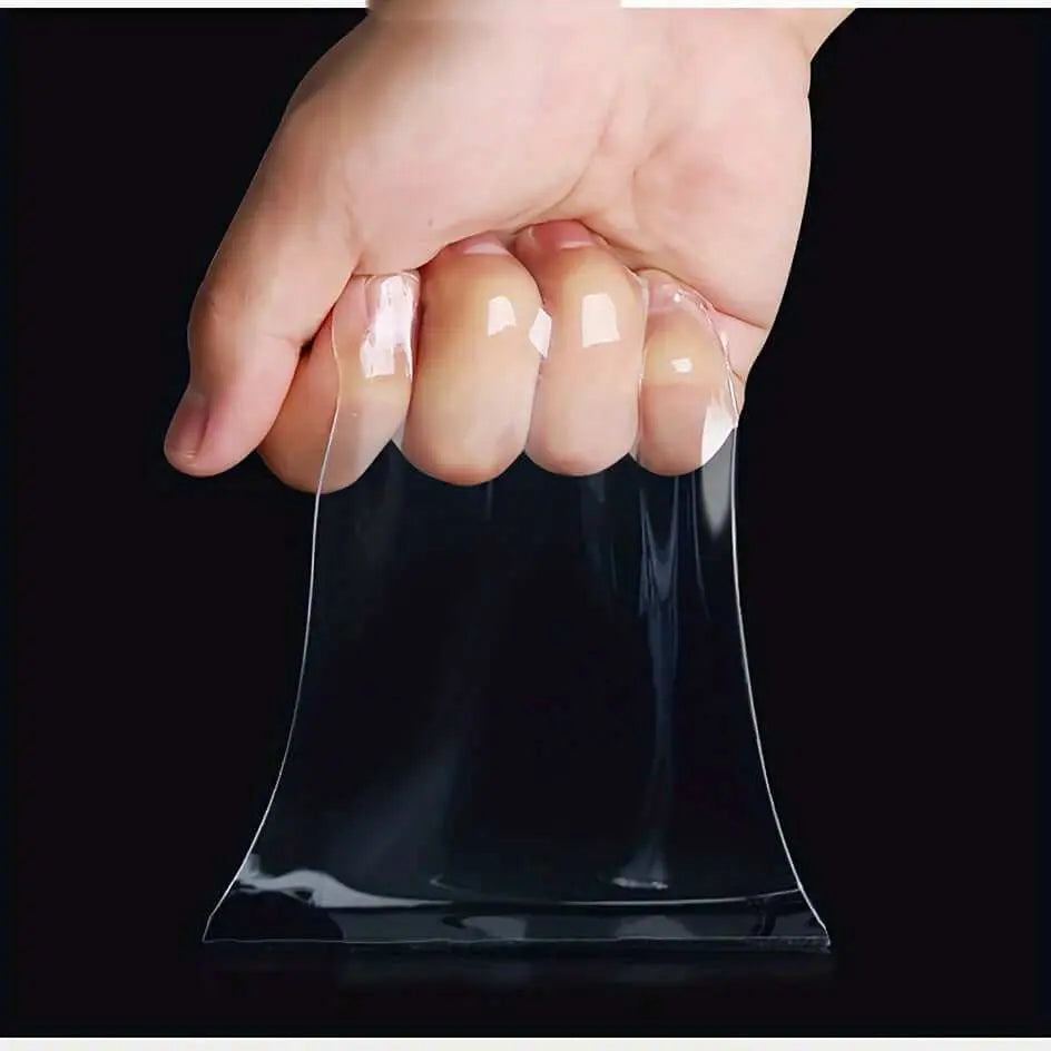 Hand holding transparent Nano Double-Sided Tape, suitable for mounting and organizing on various surfaces.