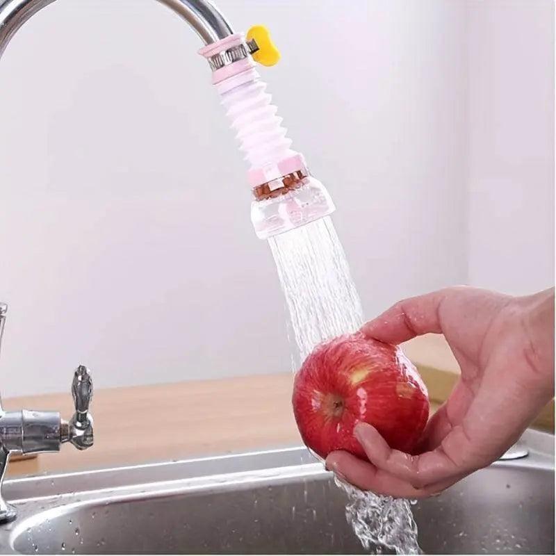 Splash-proof shower header attached to faucet, preventing water splashes while washing an apple in the kitchen sink.