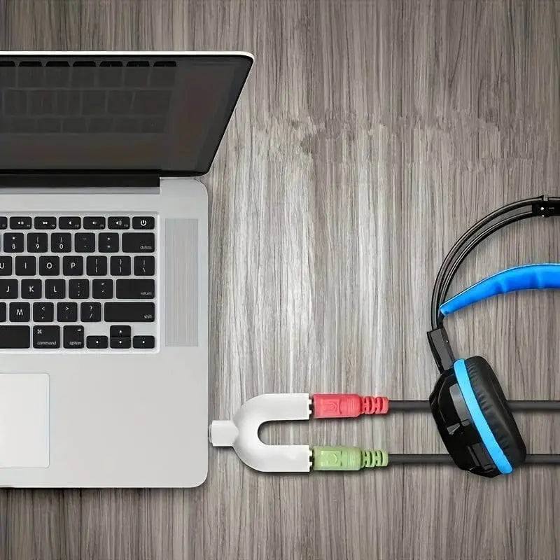 MacBook connected to headphone jack splitter showing multiple headphone output setup.