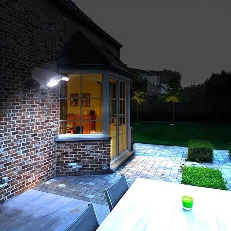 Outdoor patio illuminated by Solar-Powered LED Spotlight with Motion Sensor, mounted on brick wall.