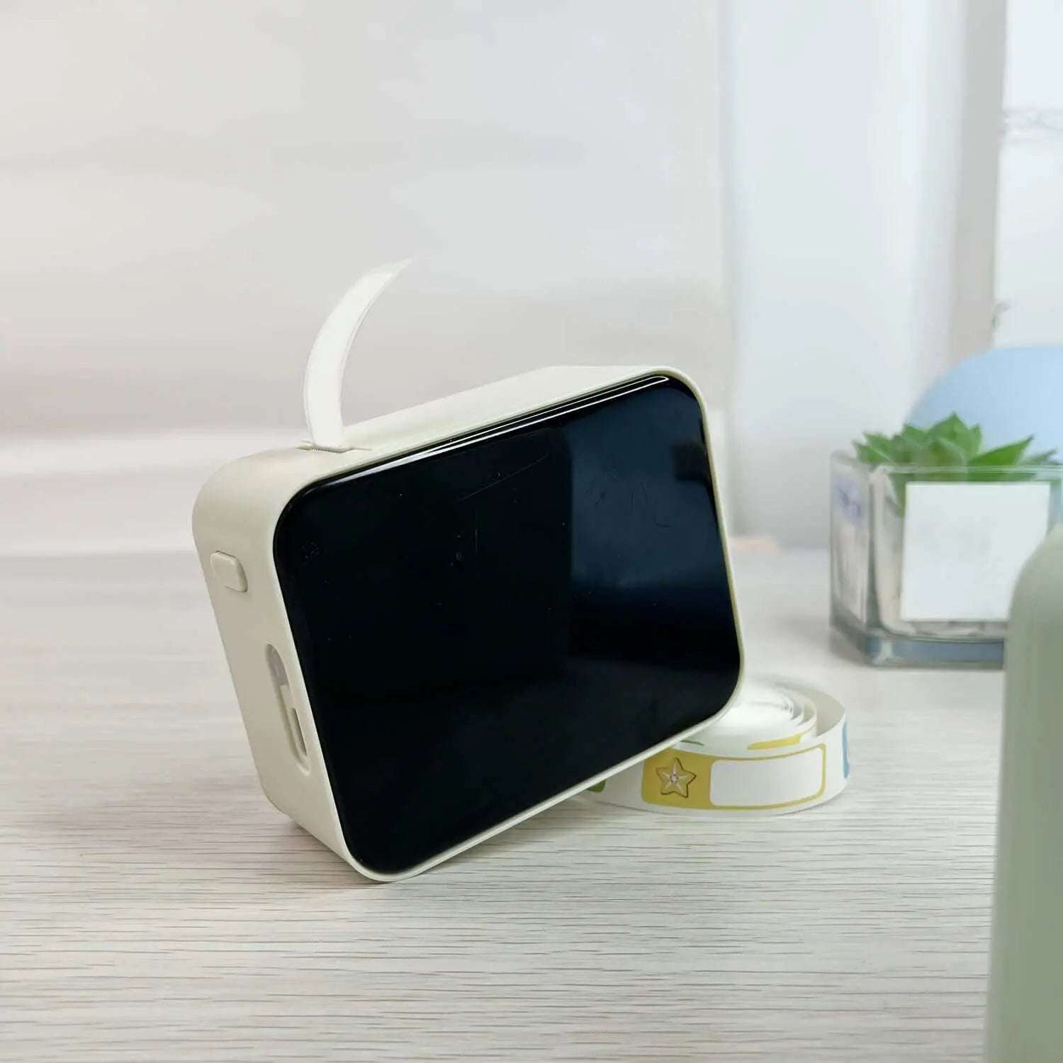 Portable thermal label printer with wireless capabilities on a table.