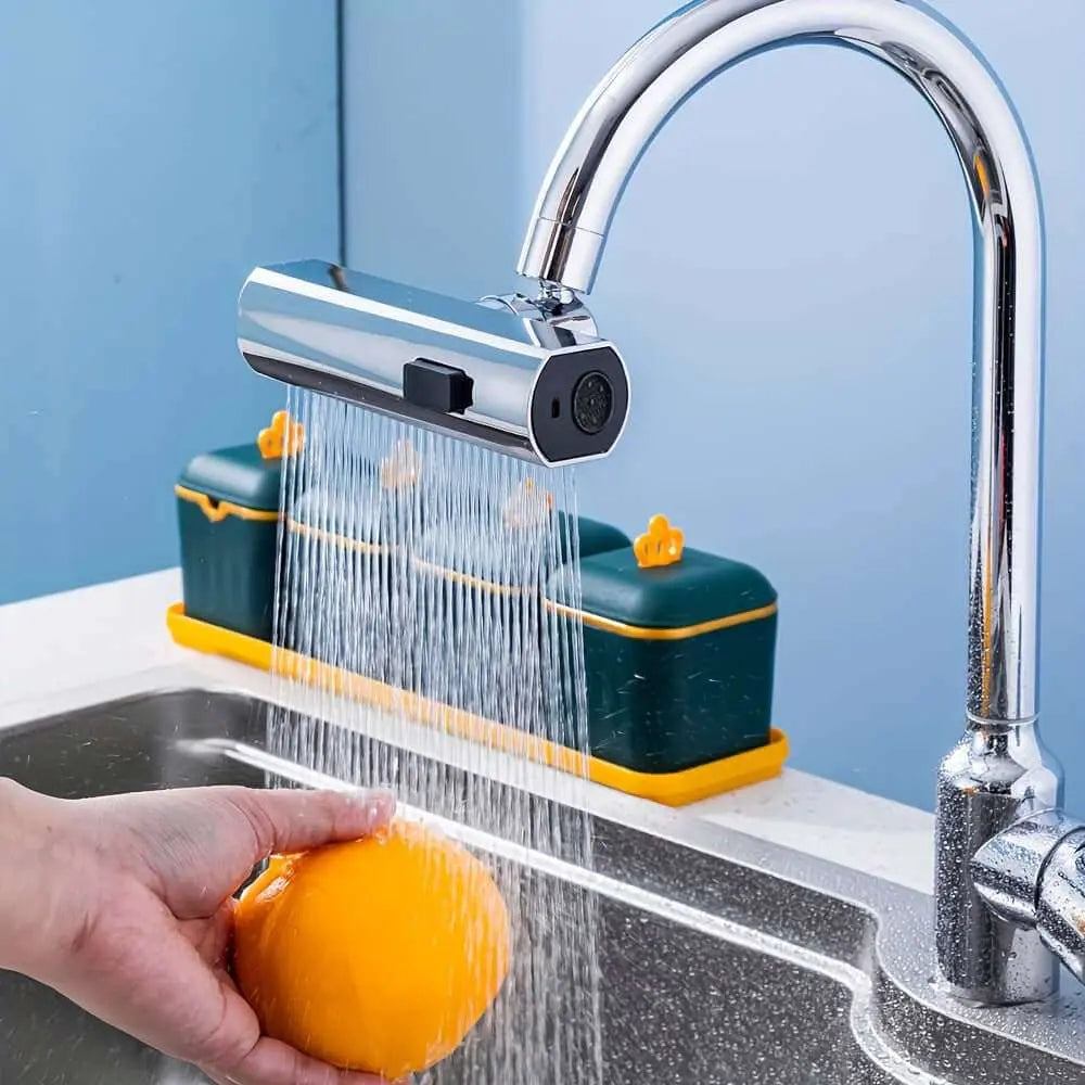 Three-mode water shower with spray setting rinsing an orange in kitchen sink.